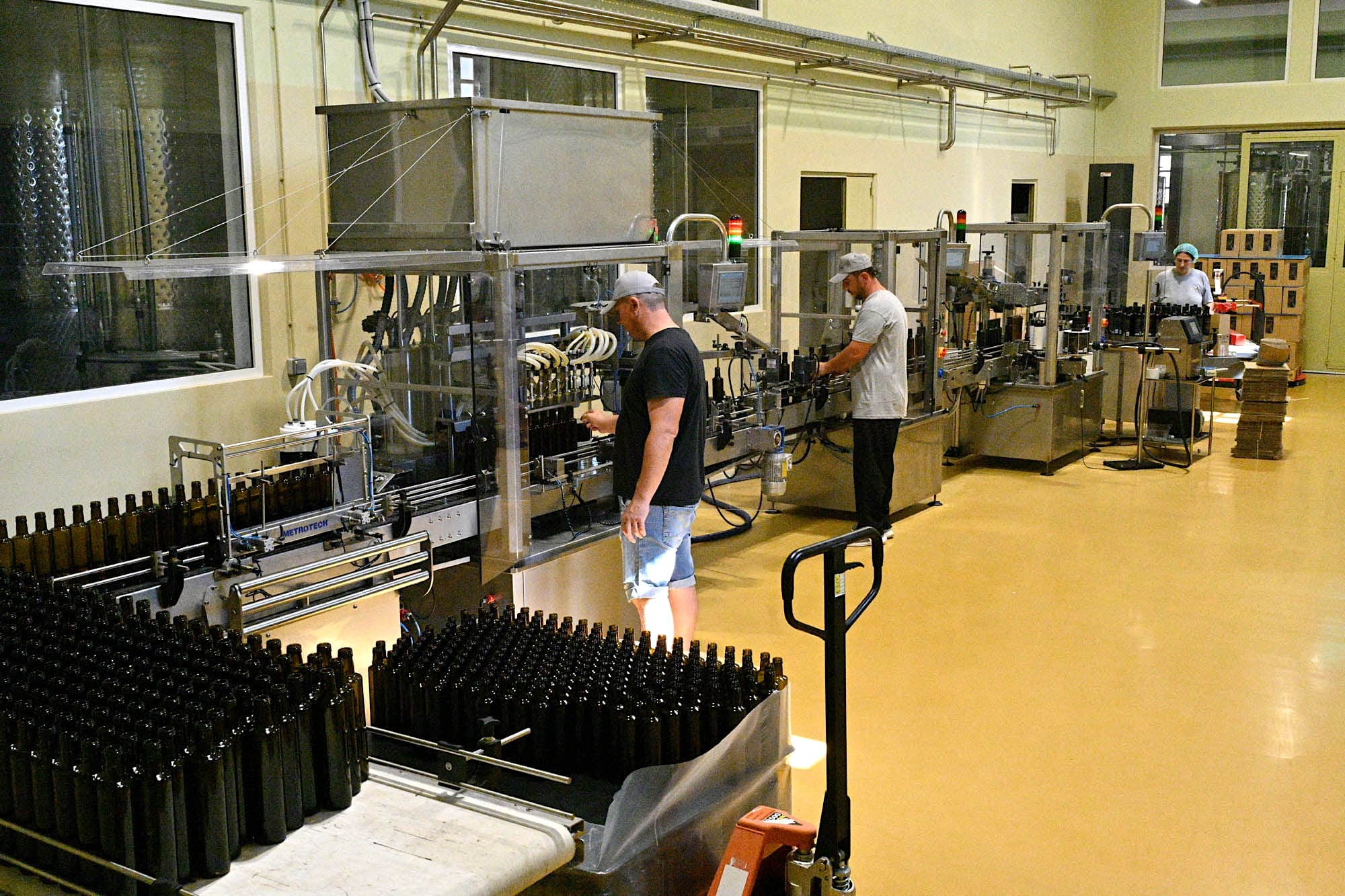 The bottling line, with crates of empty bottles and the team at work