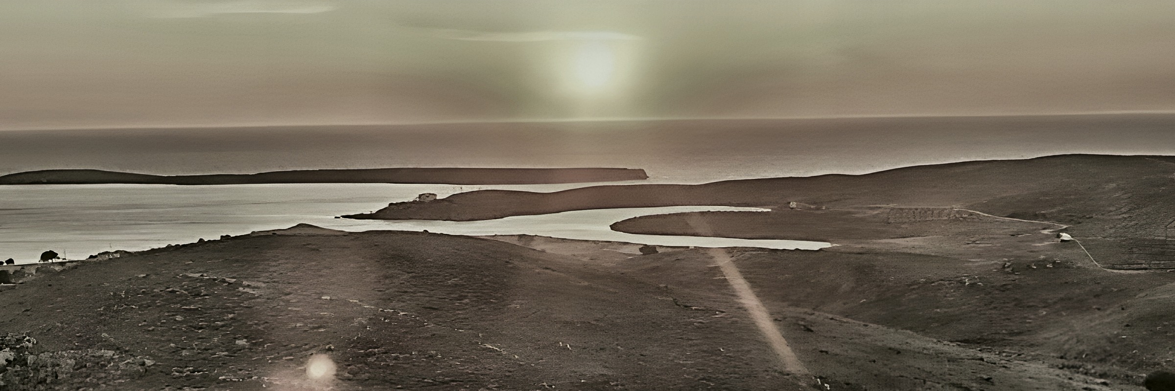 The same land in 1990: bare hills above the lagoon at Sigri