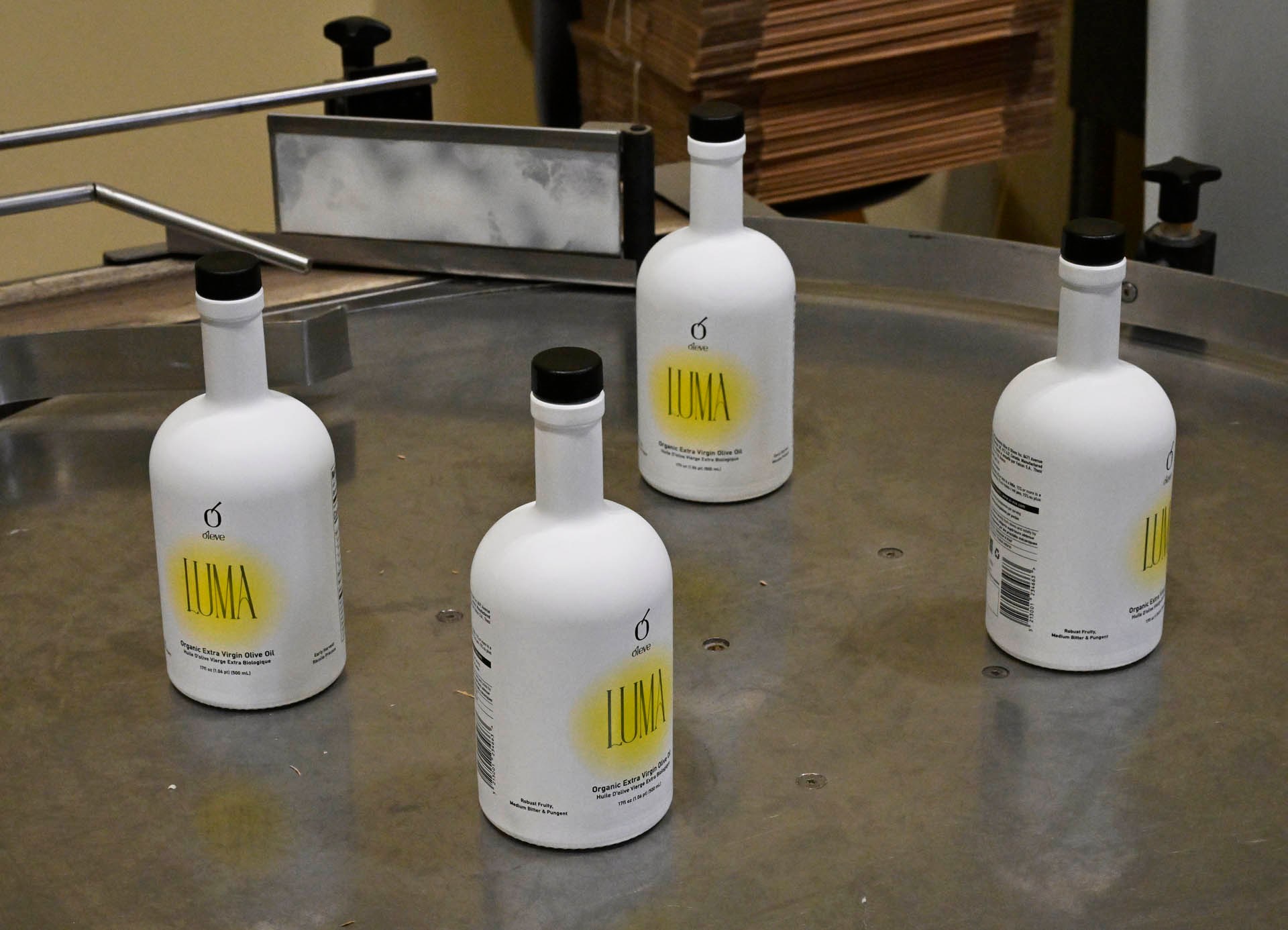 Bottles of Ol-eve LUMA organic extra virgin olive oil on the rotary table