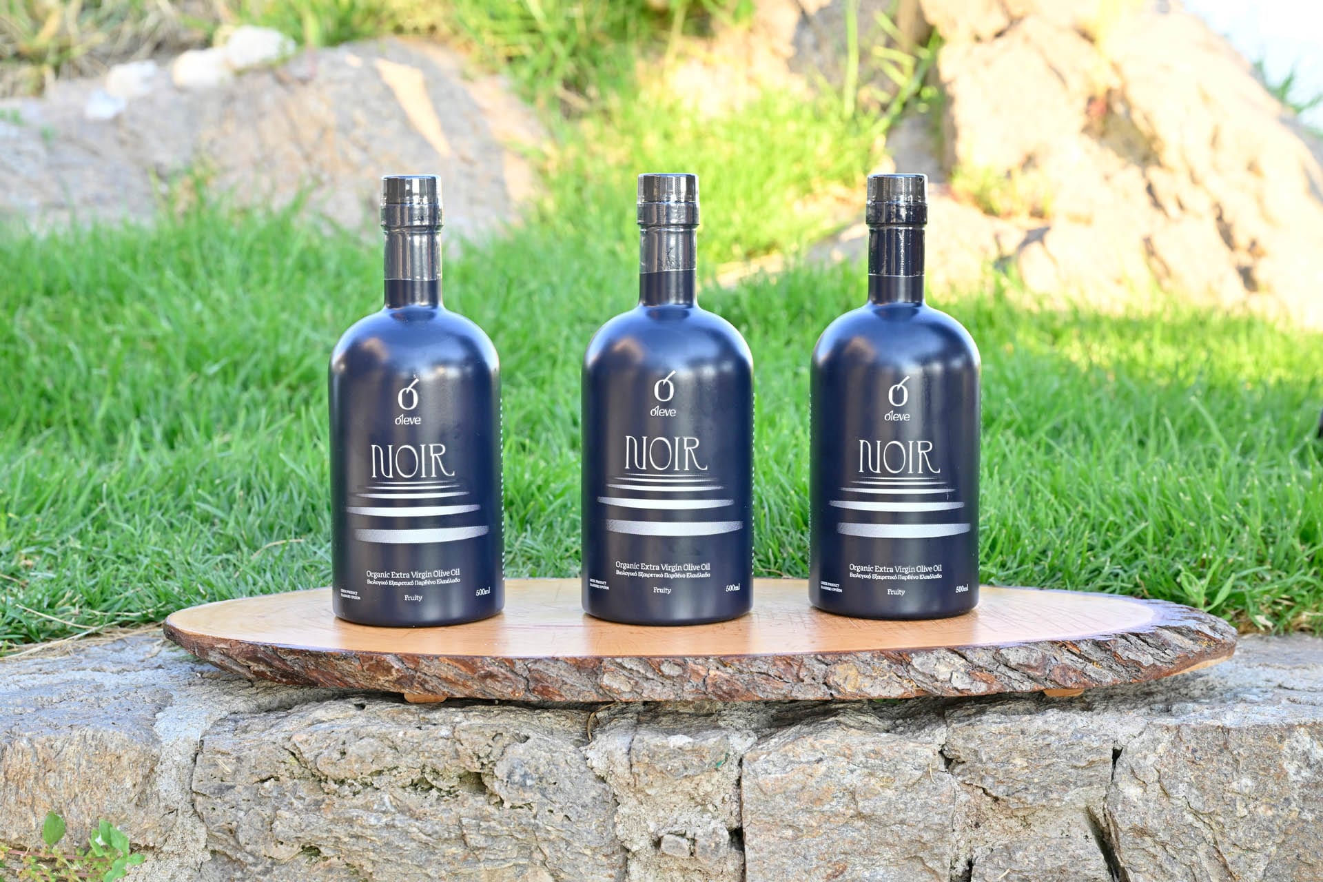 Three bottles of Ol-eve NOIR on a wooden board