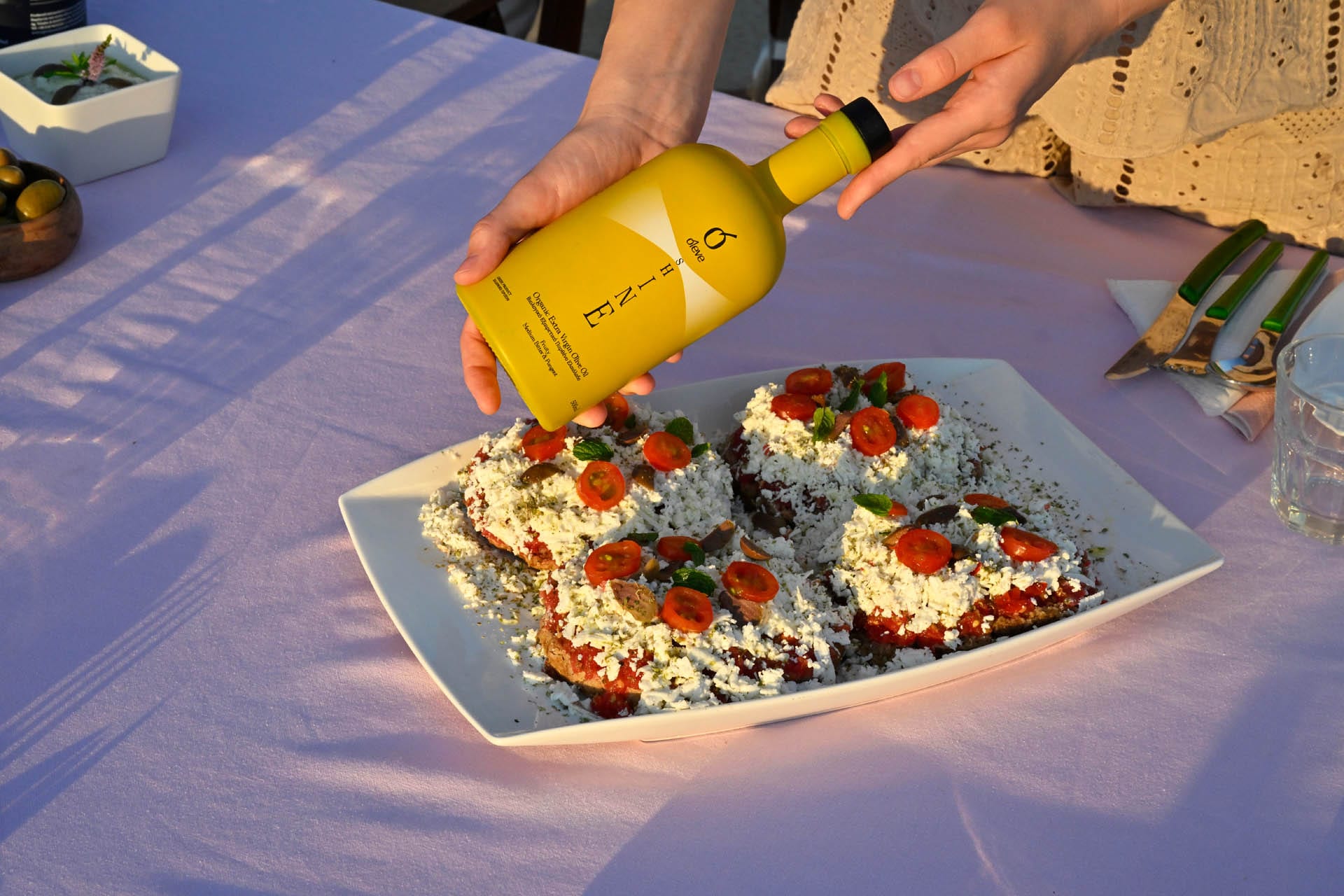 Ol-eve SHINE drizzled over dakos — barley rusks with tomato and feta