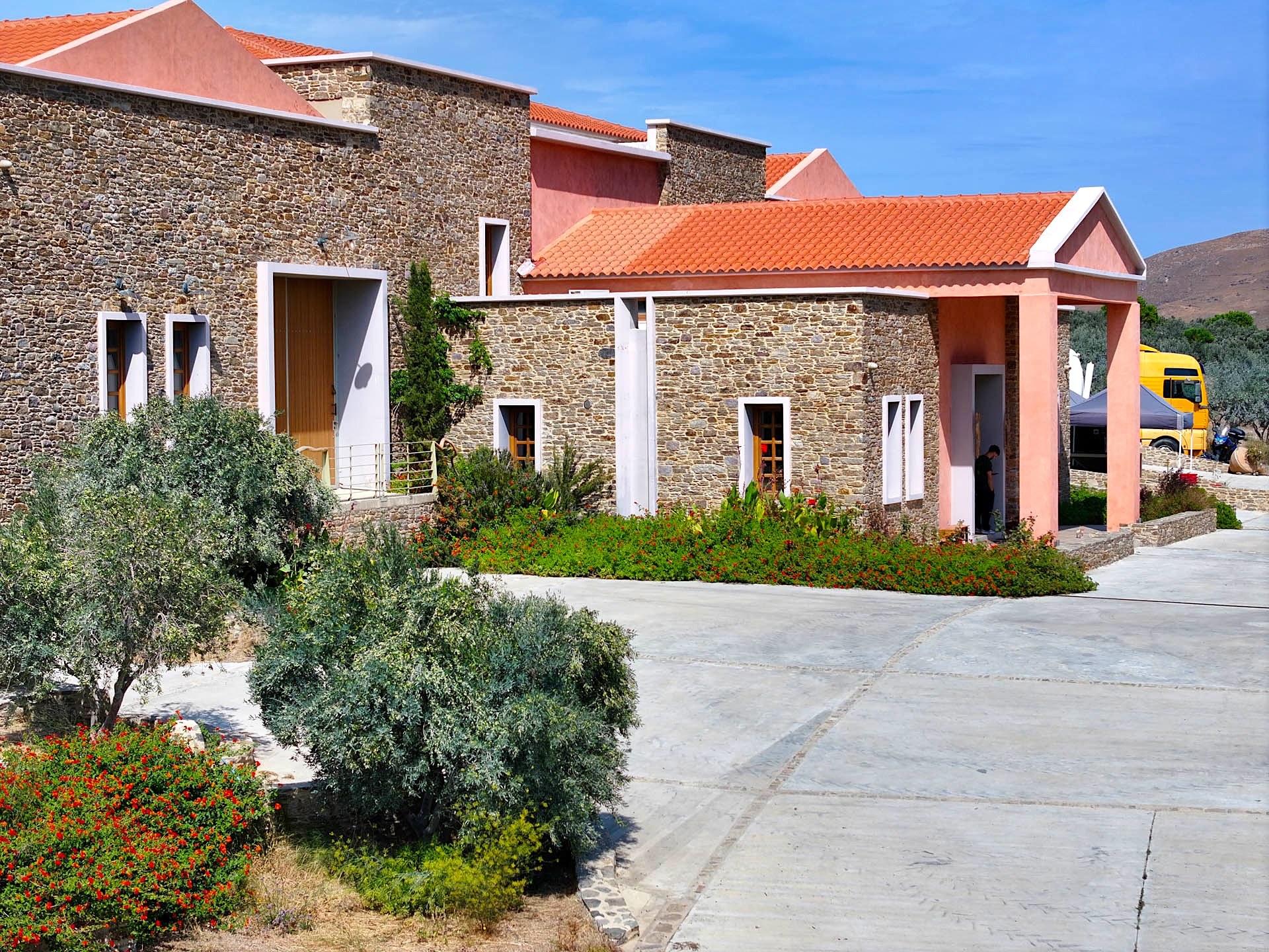 The pink portico at the mill’s entrance, among olive trees and red flowers