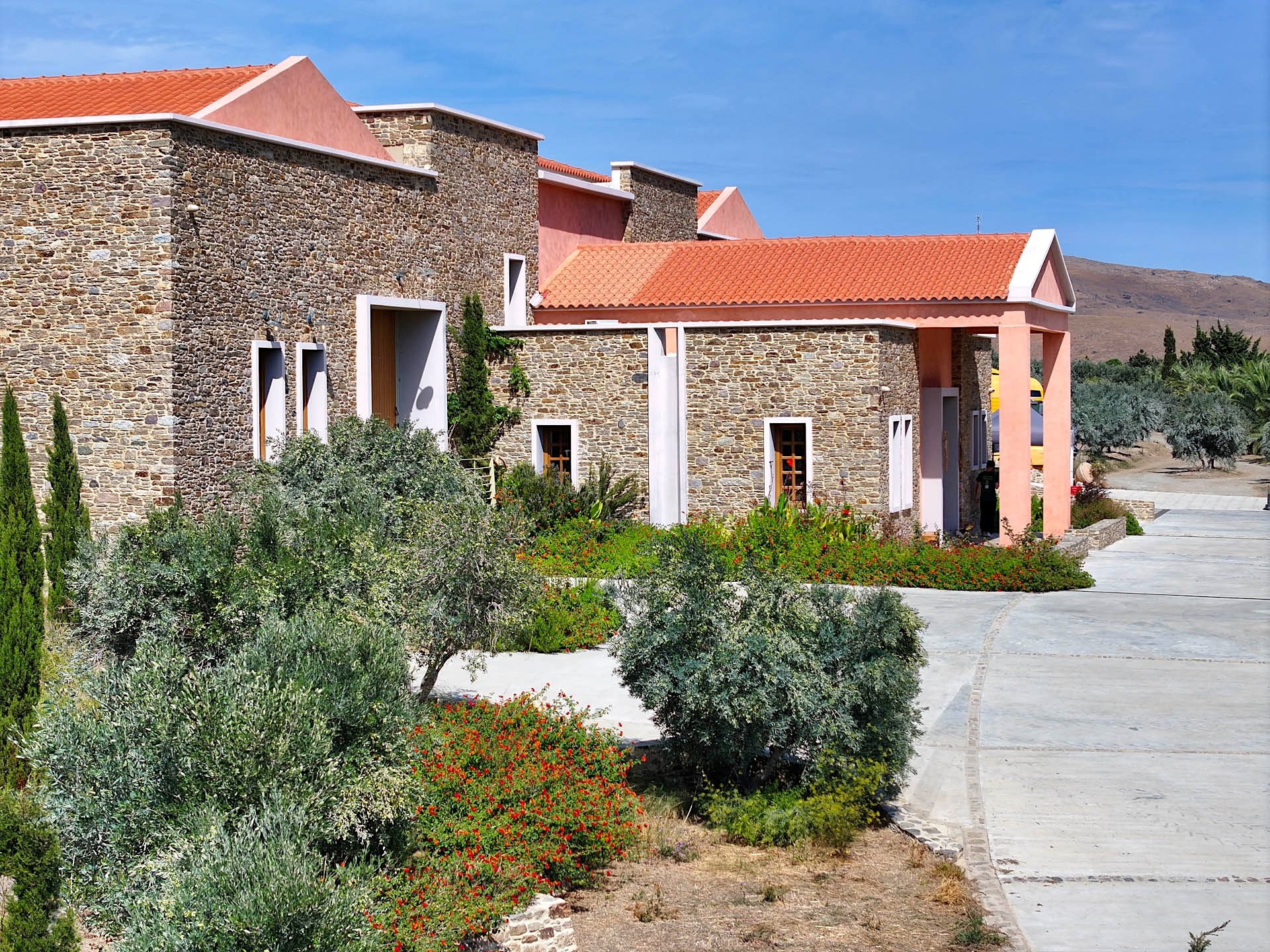 Sigri Olive Mill: stone walls, terracotta roofs and a pink portico behind the garden’s olive trees