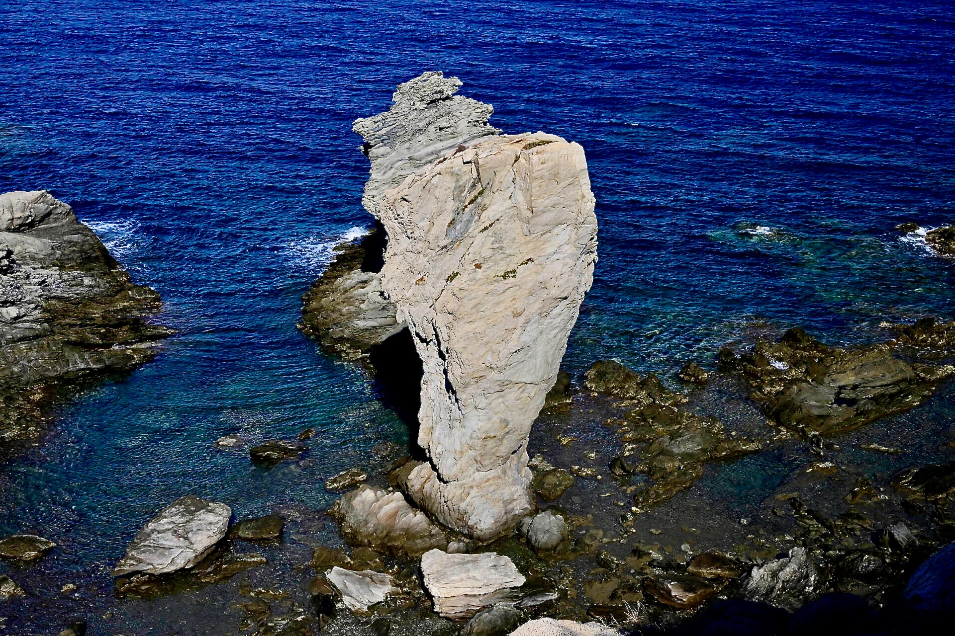 A rock pillar in the sea, seen from the cliff above