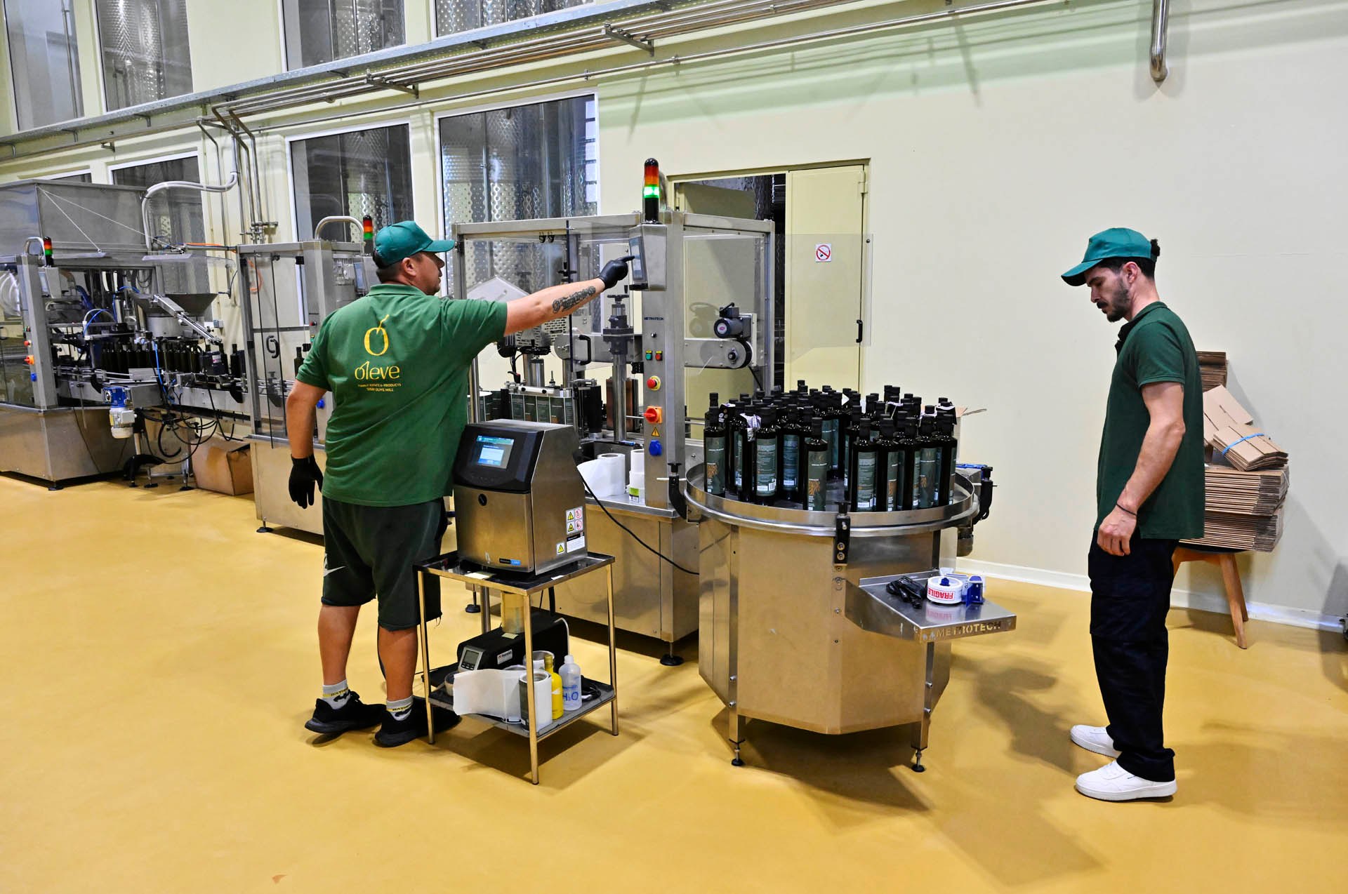 Setting up the labelling machine, the bottles waiting on the rotary table