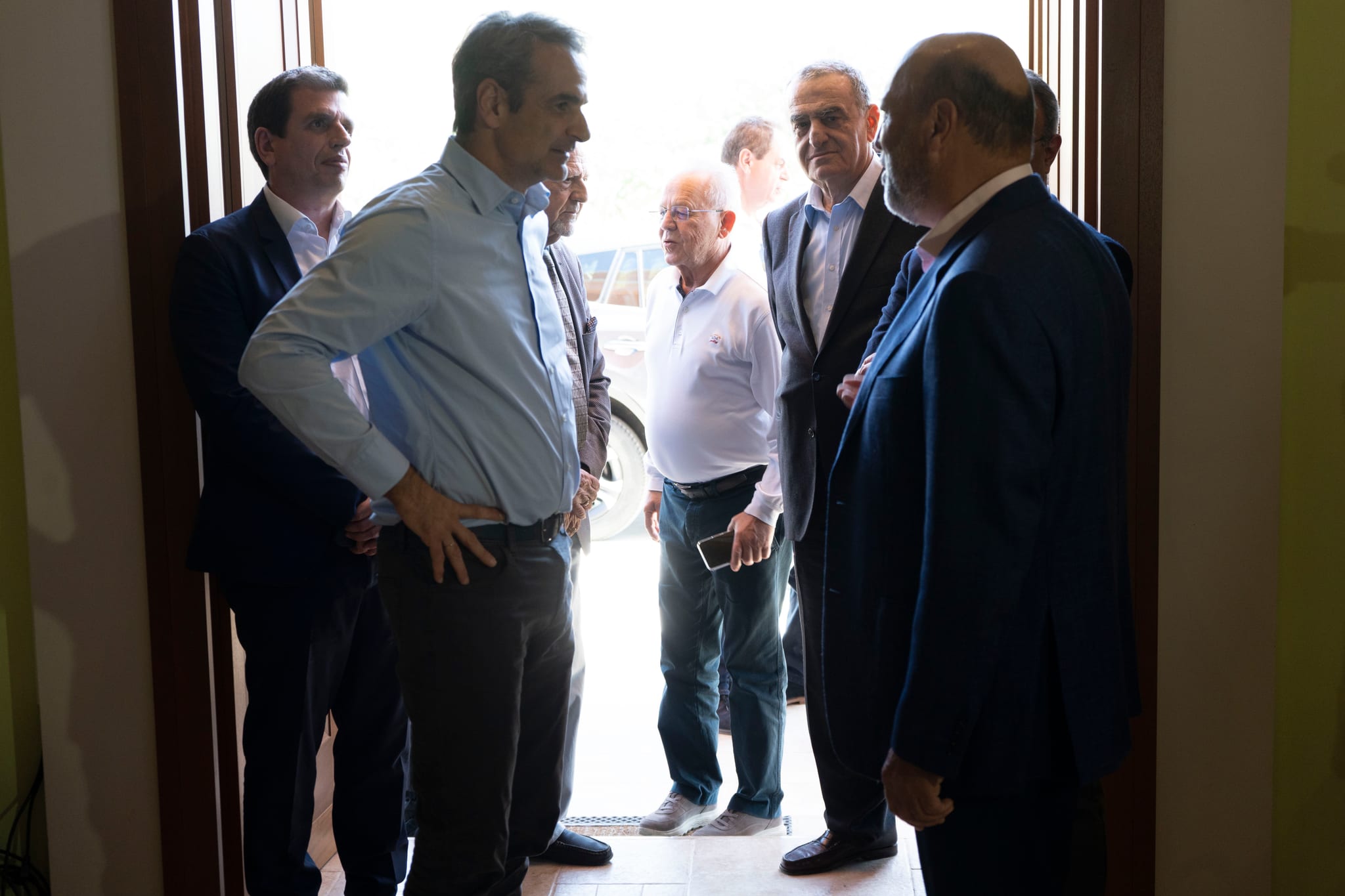 Prime Minister Mitsotakis talks with hosts and guests at the entrance of Sigri Olive Mill